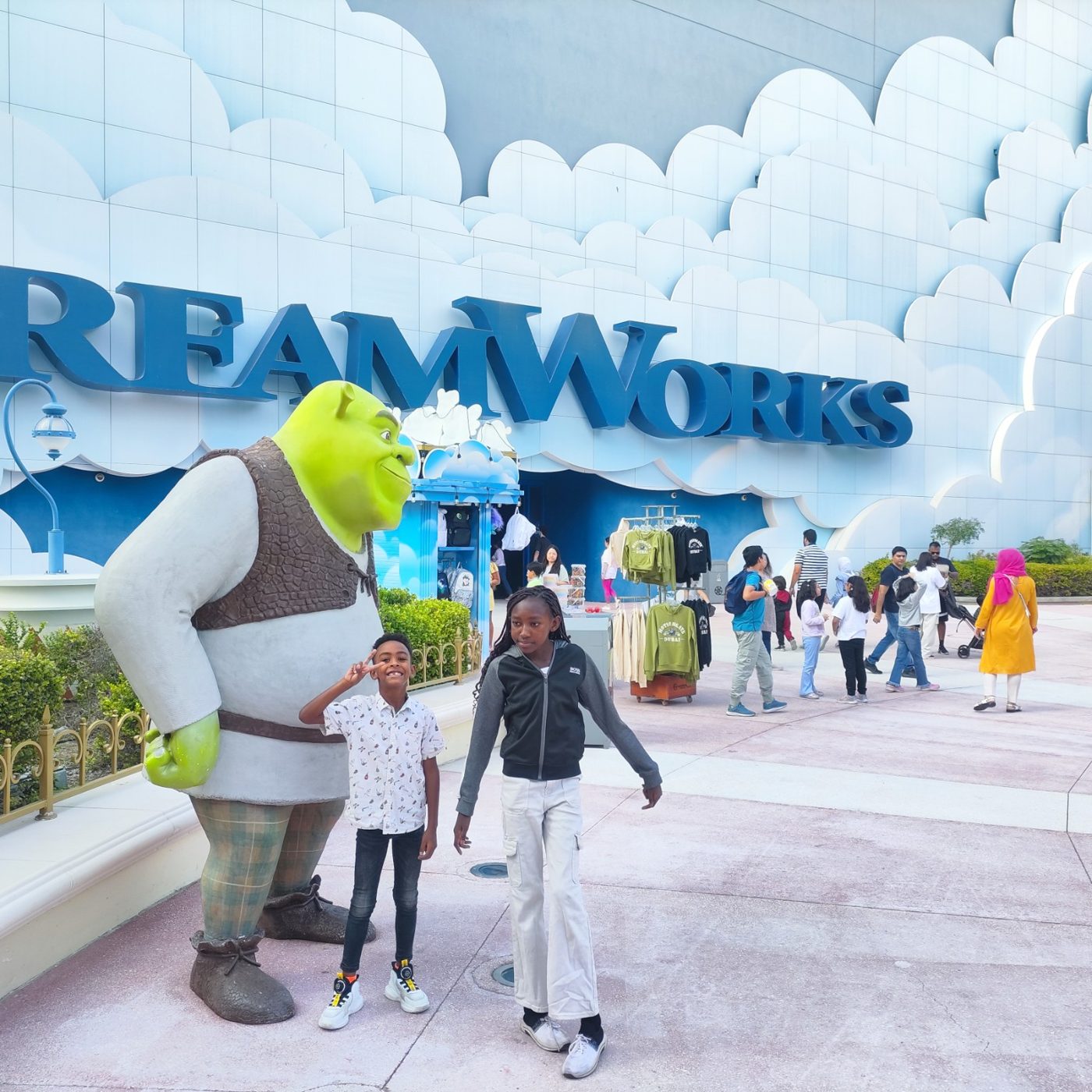 Two children with a Shrek statue outside the DreamWorks area.